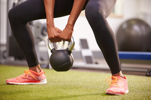 Woman-exercising-with-a-kettlebell-weight,-low-section-crop-481448630_5184x3456.jpeg